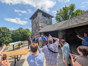 Action photo of cutting the ribbon in front of Eliot Tower.